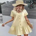 Detalle exterior de un vestido amarillo de algodón y lino con botones y volantes. - S / Vestidos / Beige