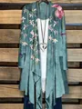 Gesamtansicht eines blauen Cardigans mit Blumenmuster über einem weißen Oberteil. - S / Oberteile / 1