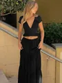 Primo piano del crop top elegante in pizzo nero e del set coordinato di gonna lunga. - Taglia S / Top E Pantaloni / Nero