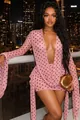 Close-up of a sexy pink polka dot deep V bodycon mini dress against a night city skyline view. - S / Dresses / Pink