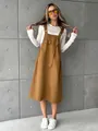 Detail of a brown loose workwear pinafore dress over a white long-sleeve top - M / Bronze