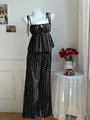 Präsentation des schwarz-weißen Polka-Dot-Tops und der weiten Hose auf einer Schaufensterpuppe - Schwarze Polka Dots