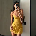 Full detail of a vibrant yellow polka dot mini slip dress worn in a casual mirror selfie - Yellow