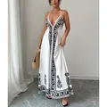 Elegant white halter neck maxi dress featuring black floral print and deep V-neckline - S / Dresses / White