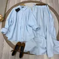 Flat lay view of women's light blue long-sleeve linen shirt and long maxi skirt set - XS / Top And Bottom / Light Blue