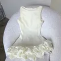 Detailed macro view of white Hepburn style sleeveless dress featuring 3D ruffled hem - XS / Dresses / White