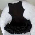 Detailed view of the intricate ruffled floral hem on a black sleeveless Hepburn style dress. - XS / Dresses / Black