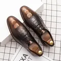 Nahaufnahme von klassischen braunen Herrenschuhen mit Kroko-Prägung und Schnürung. - 38 / Gold
