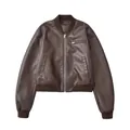 Detailed view of a vintage brown faux leather bomber jacket featuring a front silver zipper. - S / Tops / Dark Brown