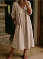 Detail of loose V-neck cotton linen dress with delicate white lace trim and pockets. - Nude