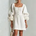 Detailweergave van witte linnen jurk met 3D-bloemenmanchetten en gepofte lantaarnmouwen - S / Dresses / Wit