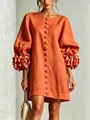 Close-up of 3D floral cuffs and lantern sleeves on an orange French style linen dress - Orange Red