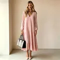 Volledige weergave van een vrouw in een roze maxi-jurk met V-hals en lange mouwen - Roze