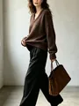 Dettaglio di un maglione marrone oversize con scollo a V in maglia - Caffè
