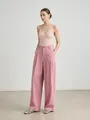Detail view of elegant pink high-waist wide-leg suit trousers on a female model. - S / Bottoms / Pink