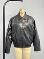 Vista frontale dettagliata di un bomber in ecopelle nera esposto su un manichino sartoriale. - XS / Top / Nero
