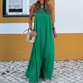 Full-length view of a vibrant green halter-neck maxi beach dress on a model outdoors. - S / Dresses / Green