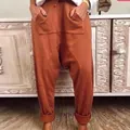 Casual rust-colored drop crotch harem pants with drawstring waist and pockets. - S / Orange