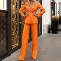Ensemble tailleur femme orange vif avec blazer et pantalon droit pour look élégant. - Orange