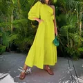 Vibrant yellow one-shoulder tiered cotton linen midi dress styled with a green bag in a garden - S / Dresses / Yellow