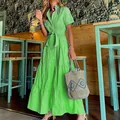 Detailed view of a green striped short sleeve tiered maxi dress in a cafe setting - S / Dresses / Green
