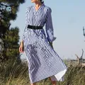 Outdoor view of a blue and white striped V-neck dress with a black belt accessory - S / Dresses / Blue