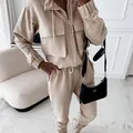 Close-up of a beige two-piece tracksuit set with a cropped jacket and jogger pants. - S / Top And Bottom / Off White
