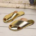 Dettaglio di eleganti sabot dorati con trama a serpente su fondo di legno bianco rustico. - 36 / Oro