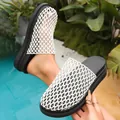 Close-up of stylish white woven mesh slippers with thick black platform soles for summer - 35 / Beige
