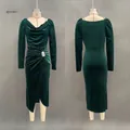 Detail view of an elegant emerald green velvet pleated maxi dress with a front slit. - S / Dresses / Green