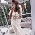 Detail of women's cream casual set with sequined evil eye motif on V-neck top - S / Top And Bottom / White