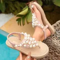 Nahaufnahme rosa Sandalen mit schweren Perlenverzierungen und einem schicken Zehentrenner-Design. - 36 / Beige
