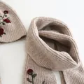 Detailed close-up of beige ribbed knit hat and scarf set with elegant red rose embroidery - Flower