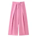 Detail view of stylish pink wide-leg trousers showing elegant drape and waist pleats. - XS / Bottoms / Pink
