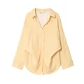 Dettaglio di camicia a righe gialle con maniche a pipistrello e tasca frontale. - Quadri Giallo