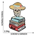 Detailed embroidered cartoon skeleton patch wearing a sun hat on a stack of books - Single Piece (7.0x3.9)