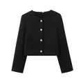 Vue détaillée d'une veste courte classique en tweed noir avec des boutons dorés - Noir