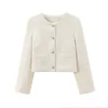 Vue détaillée d'une veste courte en tweed crème avec des boutons argentés et poches - Beige