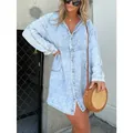 Woman styling a light blue acid-wash denim shirt dress with a boho straw bag outdoors - Light Blue