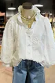 Close-up of elegant white cotton blouse featuring floral embroidery and ruffled puff sleeves - S / Tops / White