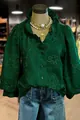 Detailed view of the intricate floral embroidery and ruffle trim on green puff sleeve blouse - S / Tops / Green
