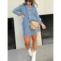 Detailed view of a washed blue denim shirt dress with lantern sleeves on a model. - Denim Blue