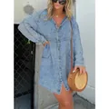 Close-up detail of a loose-fit V-neck acid wash denim shirt dress worn by a model - S / Dresses / Blue