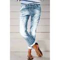 Detailed shot of women's light blue washed distressed denim jeans with multi-button fly - XS / Bottoms / Light Blue