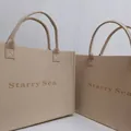 Detailansicht der minimalistischen beige Filztragetasche mit Starry Sea Gravur. - Beige