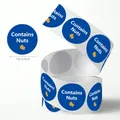 Detailed view of 1-inch round 'Contains Nuts' food warning stickers on a roll. - 500 Pieces/Pack