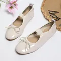 Detailed view of cream patent leather ballet flats with elastic strap and bow - 35 / Beige