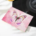 Primo piano di un biglietto d'auguri farfalla 3D con motivi floreali rosa e vinile. - Farfalla Rossa Arcobaleno