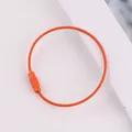 Macro view of a durable orange steel wire keychain with a secure rotating screw lock. - Orange