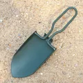 Dettaglio di una piccola pala pieghevole da campeggio verde su fondo di sabbia naturale - Verde militare